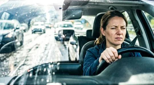 Conducente alla guida con riverbero intenso sul parabrezza che causa affaticamento visivo