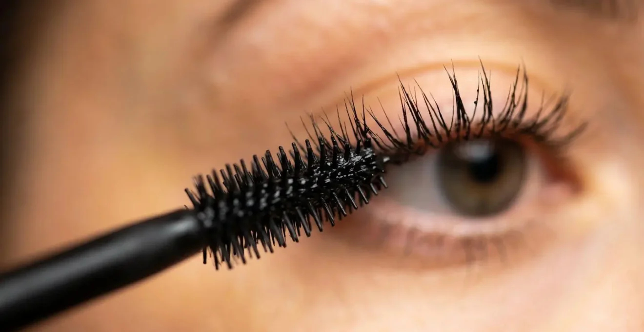 Dettaglio macro di ciglia perfettamente separate durante applicazione mascara professionale