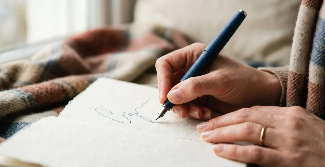 Mani che scrivono delicatamente su un diario in un momento di riflessione tranquilla con luce naturale