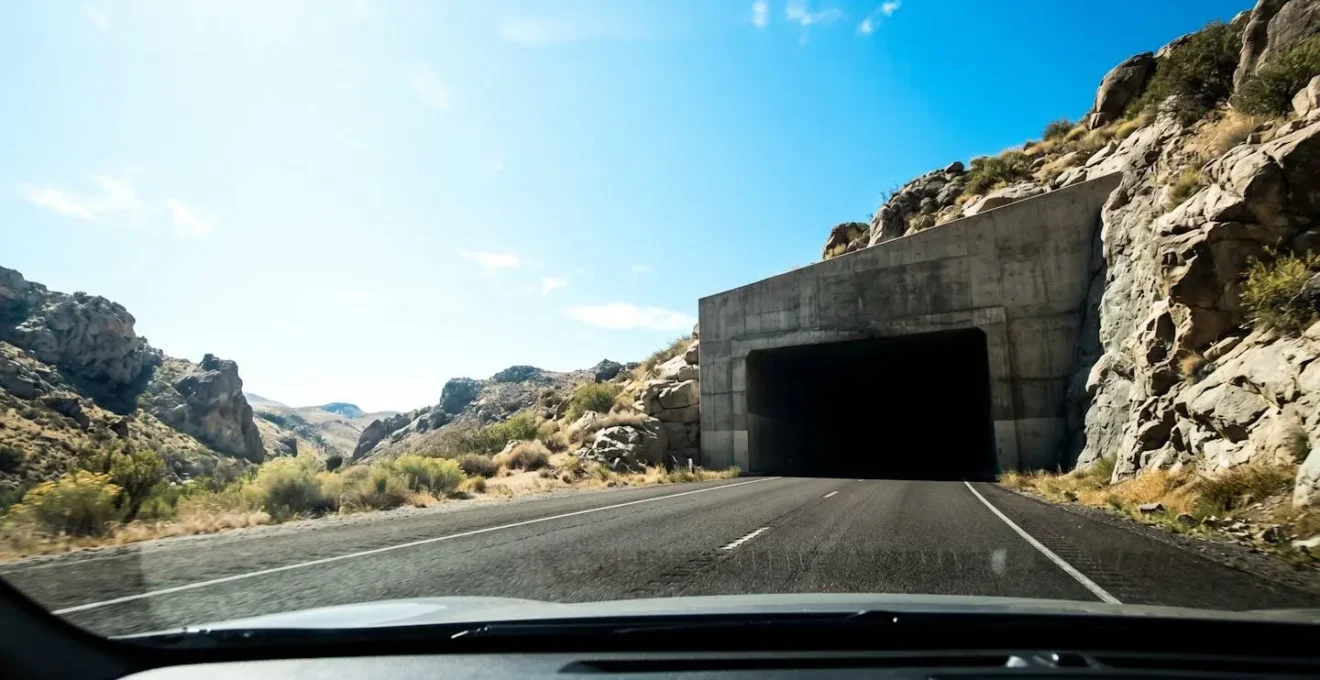 Ingresso di una galleria autostradale con forte contrasto tra luce esterna e oscurità interna